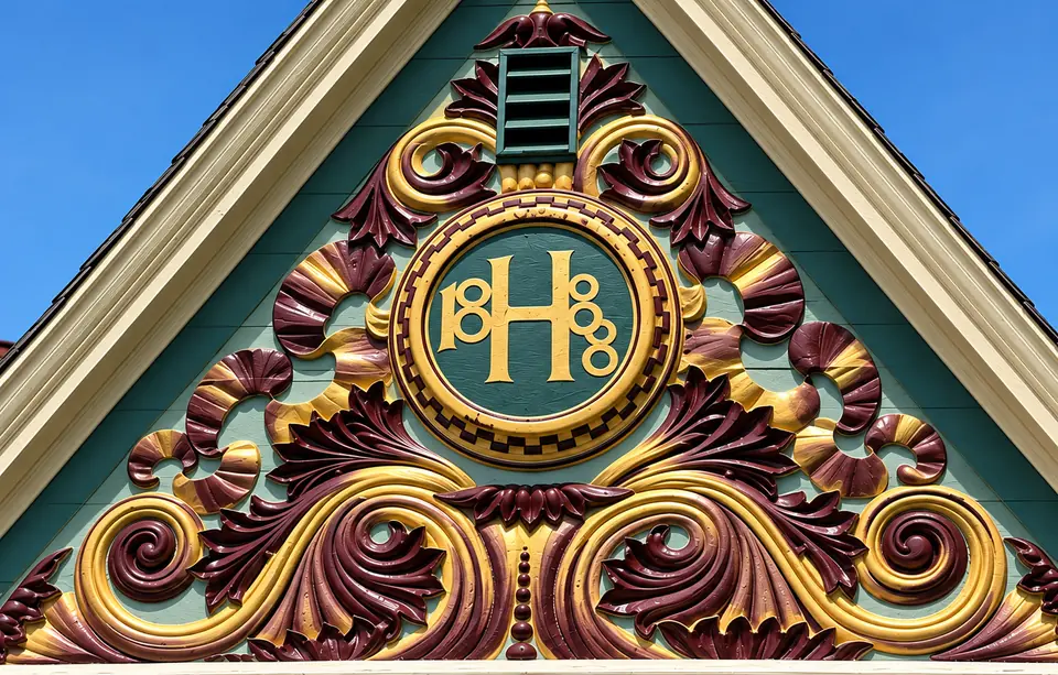 The completed Harris crest restoration: a gold H and 1888 on green, with burgundy and gold carving around them.