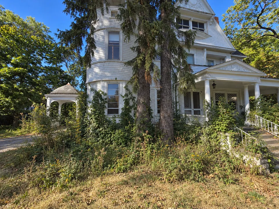 A rendering of the tower side of the house as it was: weeds and vines over the foundation and the beds, and the lawn gone to seed.